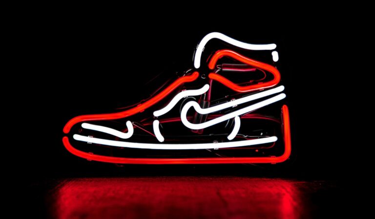 Red and white neon sign of Nike shoe