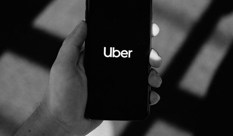 Hand holding a phone with the Uber app