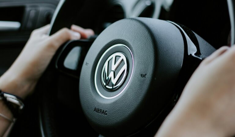 Hands on a steering wheel with Volkswagen logo