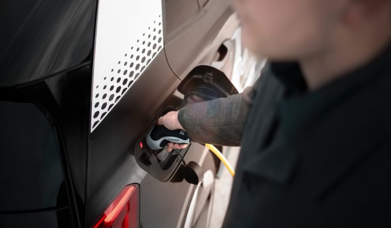 A man charging an electric vehicle