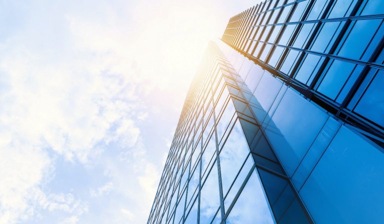 Tall building from the ground with sun behind