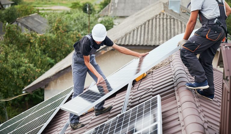 Men installing solar panels on roof