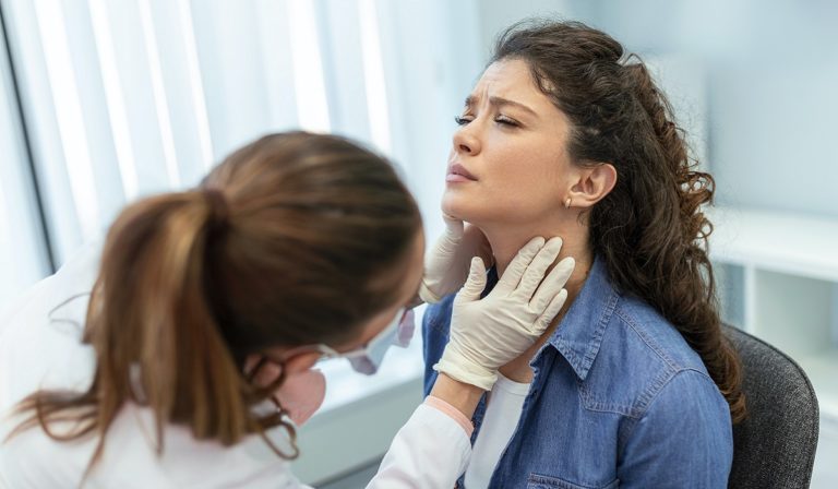 Woman being screen for thyroid condition in neck