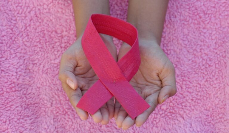 Holding breast cancer ribbon