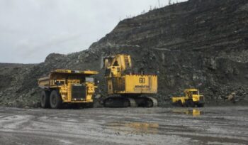 A photo of three mining vehicles parking at the coal mine