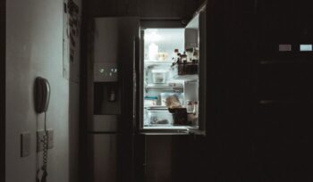 A refrigerator in a kitchen at night