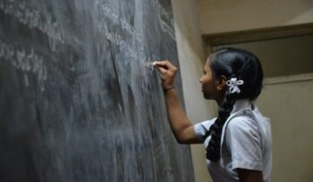 A student writing on a chalkboard