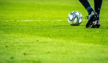 Feet and soccer ball on turf