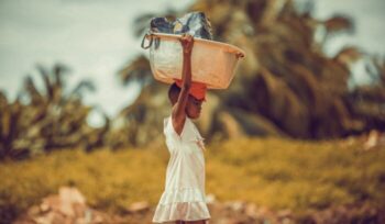 Ghanaian child carrying load on head