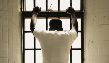 Man holding on to prison bars