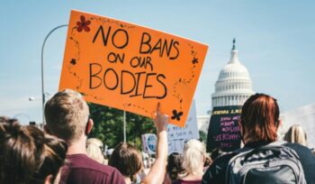 "No Bans On Our Bodies" protest sign in front of U.S. Capitol Building