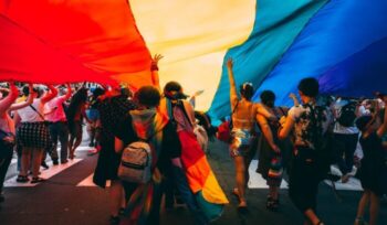 People holding up LGBTQ rainbow flag