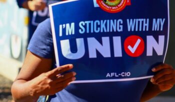 Person holding "I'm sticking with my union" sign