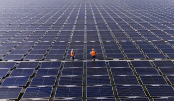 Professional workers clean and inspect solar panels on a floating buoy. Power plant with water