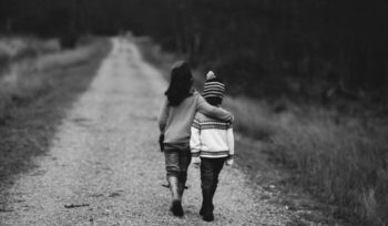 Two children walking down a road