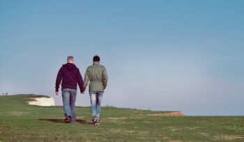 Two men walking by a cliffside